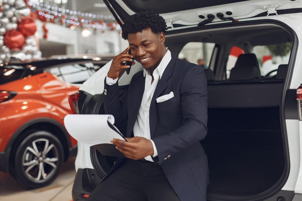 Handsome and elegant black man in a car salon